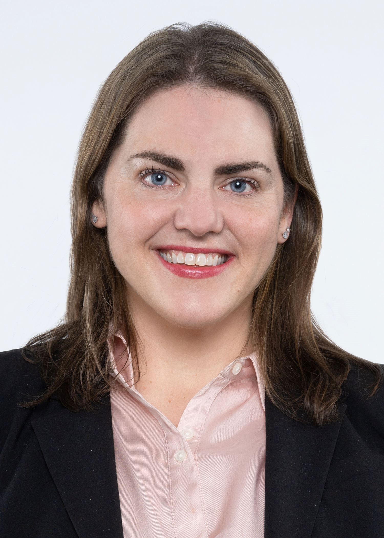 Headshot of smiling woman in a blue blazer and pink shirt